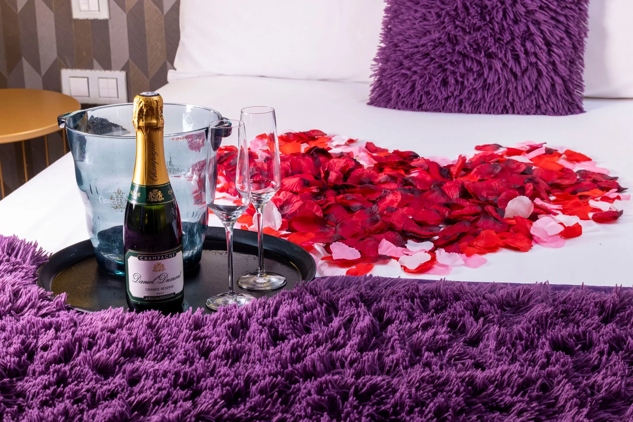 Lit avec pétales de rose et champagne.