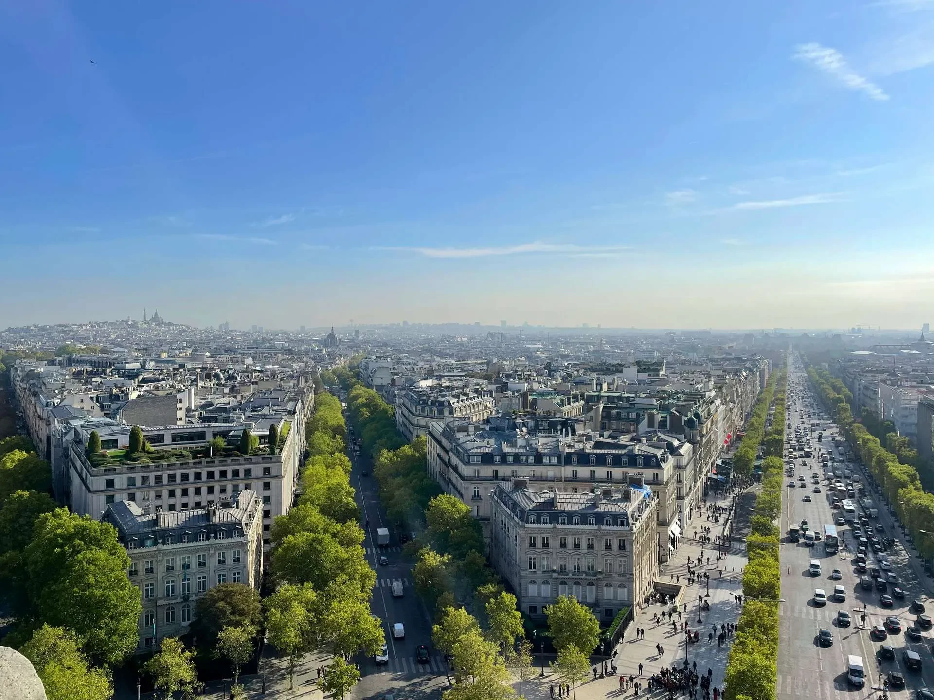 Vue panoramique de Paris avec avenue ensoleillée.