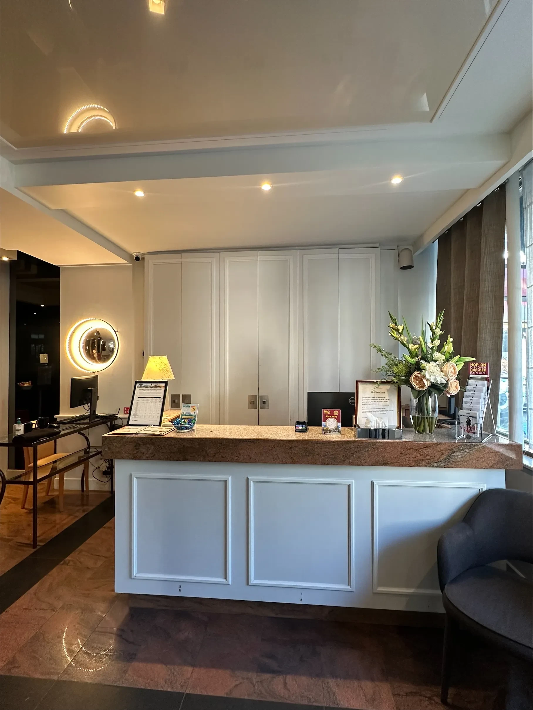 Réception d'hôtel avec bureau et fleurs.